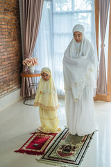 Wall Mural - muslim child learn how to pray with mom at home together