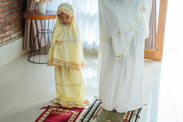 Wall Mural - muslim asian mother and daughter praying together at home