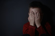 © New Africa - Scared little boy closing his eyes near black wall, space for text. Domestic violence concept