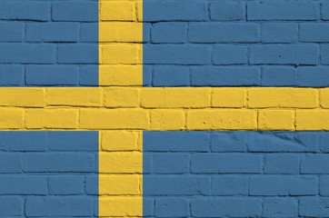 Sweden flag depicted in paint colors on old brick wall. Textured banner on big brick wall masonry background