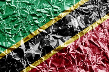 Poster - Saint Kitts and Nevis flag depicted in paint colors on shiny crumpled aluminium foil closeup. Textured banner on rough background