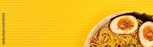 Fotografía top view of seafood ramen on yellow surface, panoramic shot
