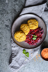 Canvas Print - Fritters made from red lentils, carrot and rolled oats served with red onion and cabbage