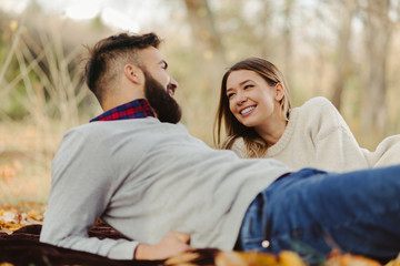 Wall Mural - Young happy couple enjoying in autumn day and talking to each other