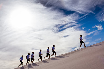 business concept  leader of the pack  competing runners competing up the hill 