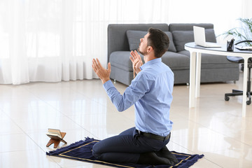 Wall Mural - Muslim man praying in office