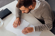 © LIGHTFIELD STUDIOS - High angle view on visually impaired man reading braille font at table