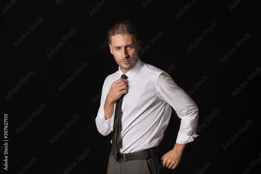 Portrait of handsome businessman on dark background