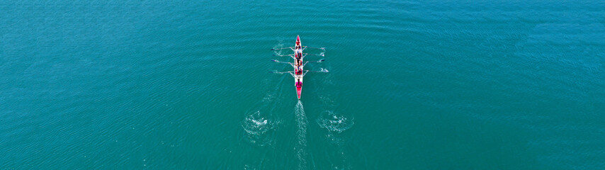 Aerial drone top panoramic view of sport canoe rowing synchronous athletes competing in tropical exotic lake