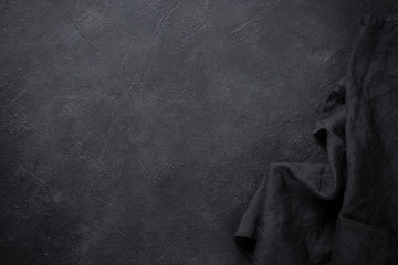 Black napkin on black stone table top view.