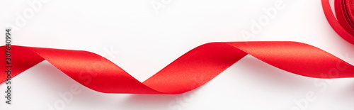 panoramic-shot-of-red-curled-ribbon-on-white-with-copy-space