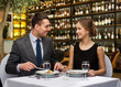 © Syda Productions - leisure and luxury concept - smiling couple eating main course over restaurant or wine bar background