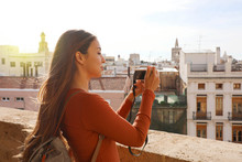Side View Of Traveler Girl Taking Picture From Terrace Of Valencia Cityscape, Spain.