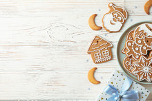 Plate With Christmas Cookies, Gift Box On White Wooden Background, Space For Text. Top View