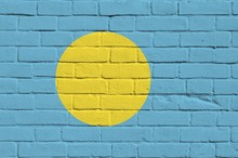 Palau Flag Depicted In Paint Colors On Old Brick Wall. Textured Banner On Big Brick Wall Masonry Background
