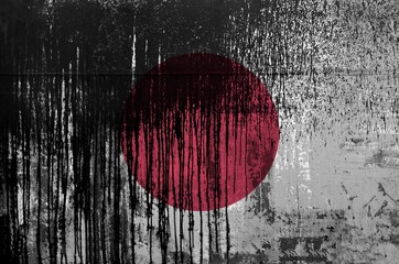 Wall Mural - Japan flag depicted in paint colors on old and dirty oil barrel wall closeup. Textured banner on rough background