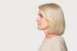 © fizkes - Mature woman profile view studio portrait isolated on gray background