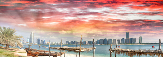 Panoramic view of Abu Dhabi Downtown skyline from the beach at sunset, UAE