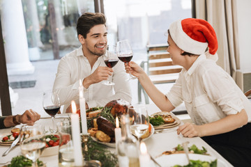 Poster - Smiling beautiful young couple celebrating Christmas together