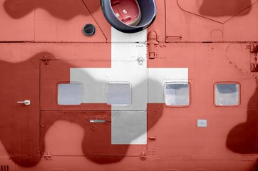 Switzerland flag depicted on side part of military armored helicopter closeup. Army forces aircraft conceptual background