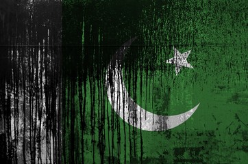 Wall Mural - Pakistan flag depicted in paint colors on old and dirty oil barrel wall closeup. Textured banner on rough background