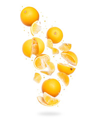 Whole and sliced fresh oranges frozen in the air, isolated on a white background