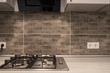 modern kitchen interior with stainless steel gas cook-top and grey tile brick backsplash