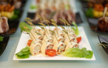 Cheese and salmon rolls. Food delivery service and catering meals on the table during the event.