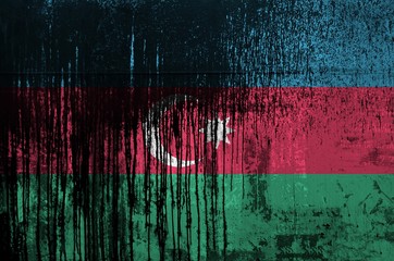 Wall Mural - Azerbaijan flag depicted in paint colors on old and dirty oil barrel wall closeup. Textured banner on rough background