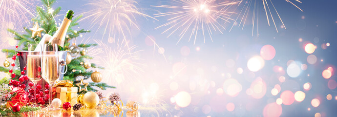 Wall Mural - new year celebration with champagne and fireworks - golden lights on blue background