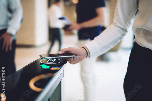 Fotografía Stylish woman walking through electronic turnstile