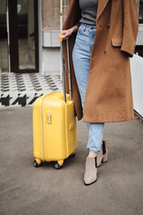  Close up casual girl in coat standing with suitcase outdoor