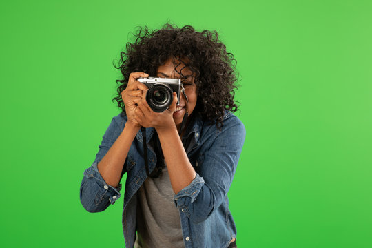Wall Mural -  - Portrait of happy black female photographer taking a photo on greenscreen