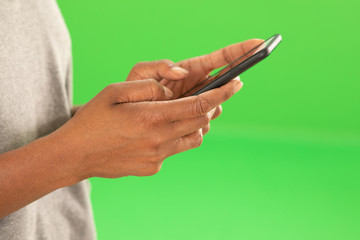 Close up of African woman's hands texting on greenscreen