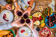 © simona - Top view of group of people clinking and toasting with glass of wine all together having fun during christmas celebration season time - concept of food and party with mixed generations family