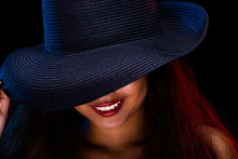 Fashion Young Tan Skin Asian Girl Long Curly Hair Red Lip And Dress Wear Dark Navy Blue Hat Pose Arm And Hand Portrait Style. Studio Lighting Black Background Isolated Copyspace Close Up