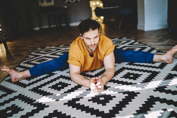 Fototapete - Young man doing yoga on floor