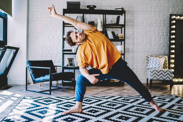 Fototapete - Young man practicing yoga asana on floor