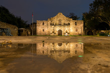 Low Angle View Of The San Antonio Alamo Reflected On Rain Puddle