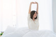 © whyframeshot - white dress asian beautiful woman stretching morning wake up bedroom with white curtain background lifestyle home concept