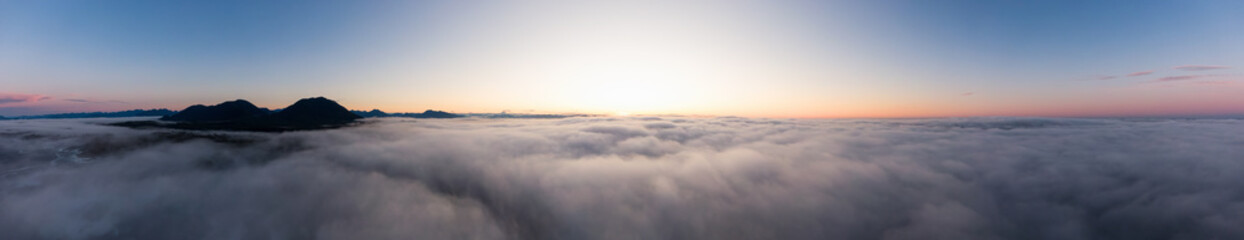 Wall Mural - Aerial Panoramic View of Pacific Ocean Coast Covered in Fog and Clouds during a colorful sunny sunrise. Taken in Vancouver Island, BC, Canada near Tofino and Ucluelet.