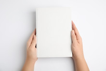 Woman Holding Book With Blank Cover On White Background, Top View