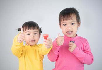 Portrait of a happy smiling brethren girls and enjoy eating gelatin dessert isolated on white background.