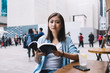 © BullRun - Asian woman reading book and looking at camera