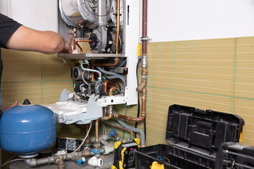 plumber fixing central heating system, Worker servicing a gas boiler