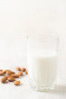 Healthy vegan nut milk and almonds on white wooden background. Selective focus, space for text.