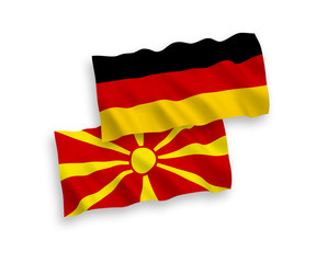 National vector fabric wave flags of Germany and North Macedonia isolated on white background. 1 to 2 proportion.