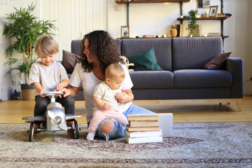 Wall Mural - Young mother with cute children at home