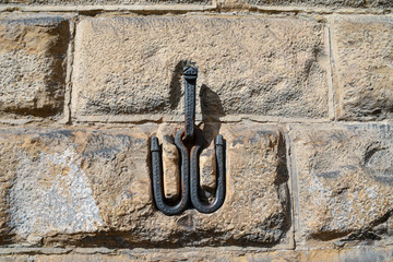 Wall Mural - Close-up of an old stone wall with a metal hook for tethering horses in the historic centre of Florence, Tuscany, Italy