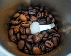 coffee grinder with roasted coffee beans...Whole coffee beans in a coffee grinder